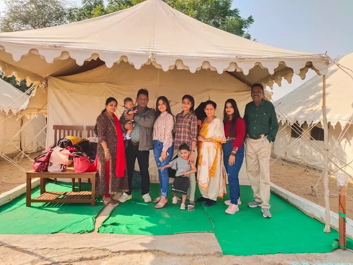 A family standing outside a Swiss tent at the Wonbin desert camp