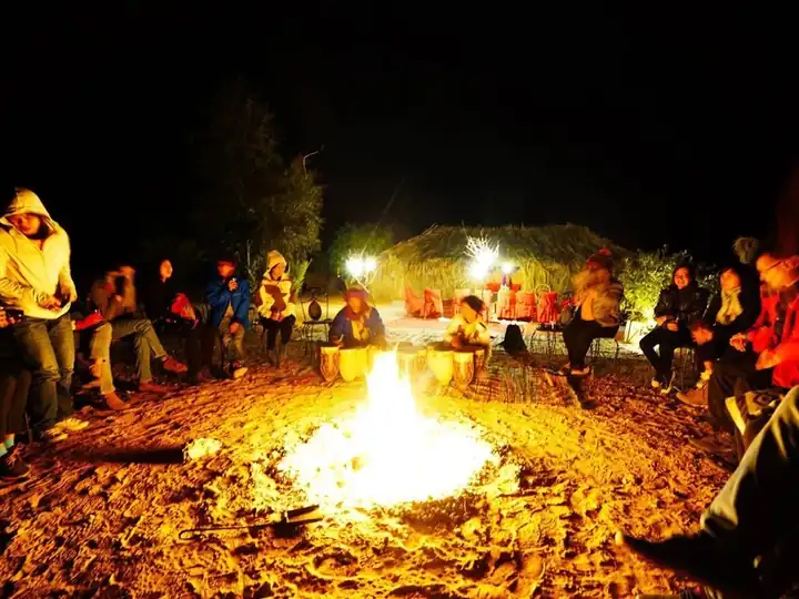 Guests sitting around the campfire at the Wonbin desert camp at night