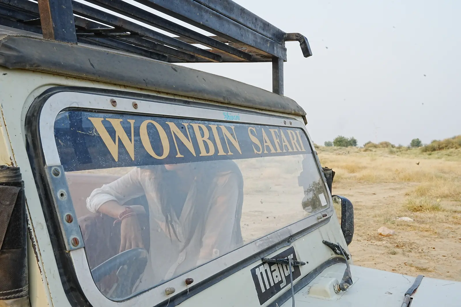 A Wonbin Safari jeep in the scrub, its name painted along the side