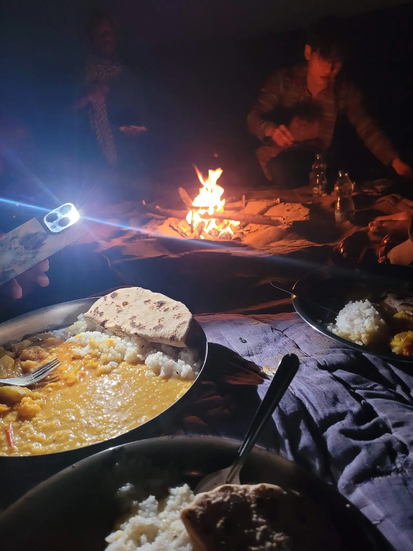 Dinner served by firelight, rice and curry on a steel plate