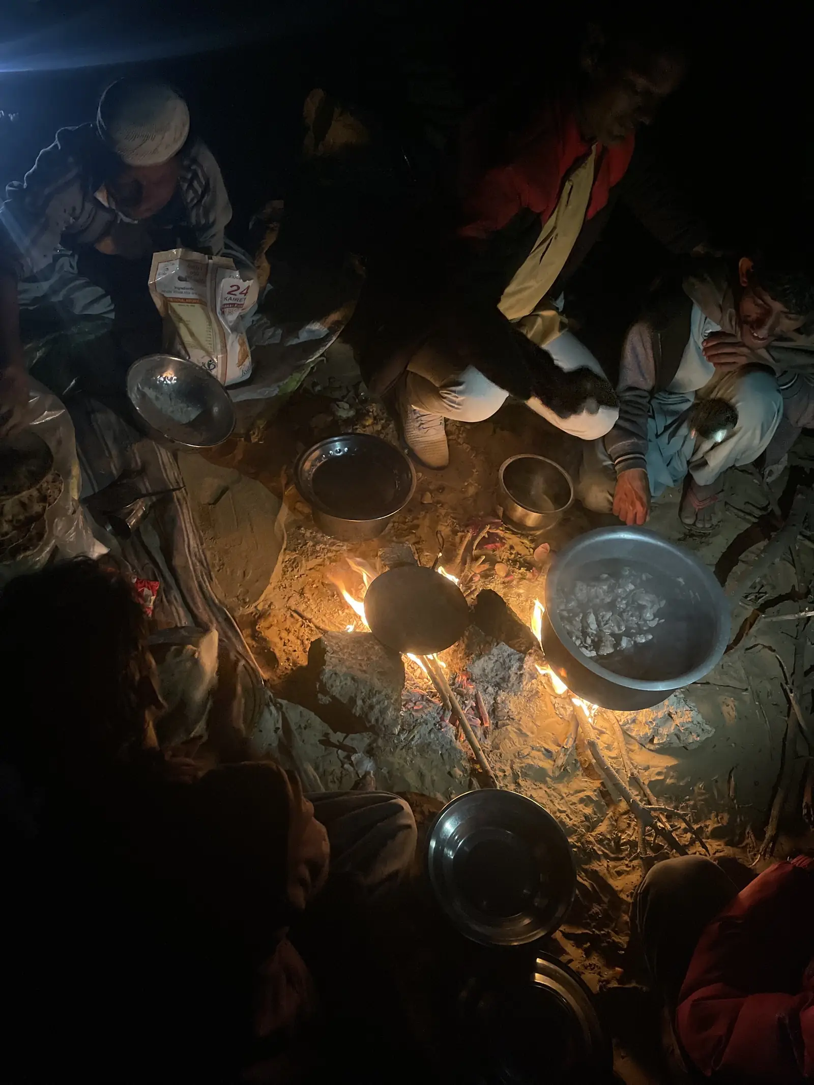 Cooking pots crowded around the fire, lit from underneath