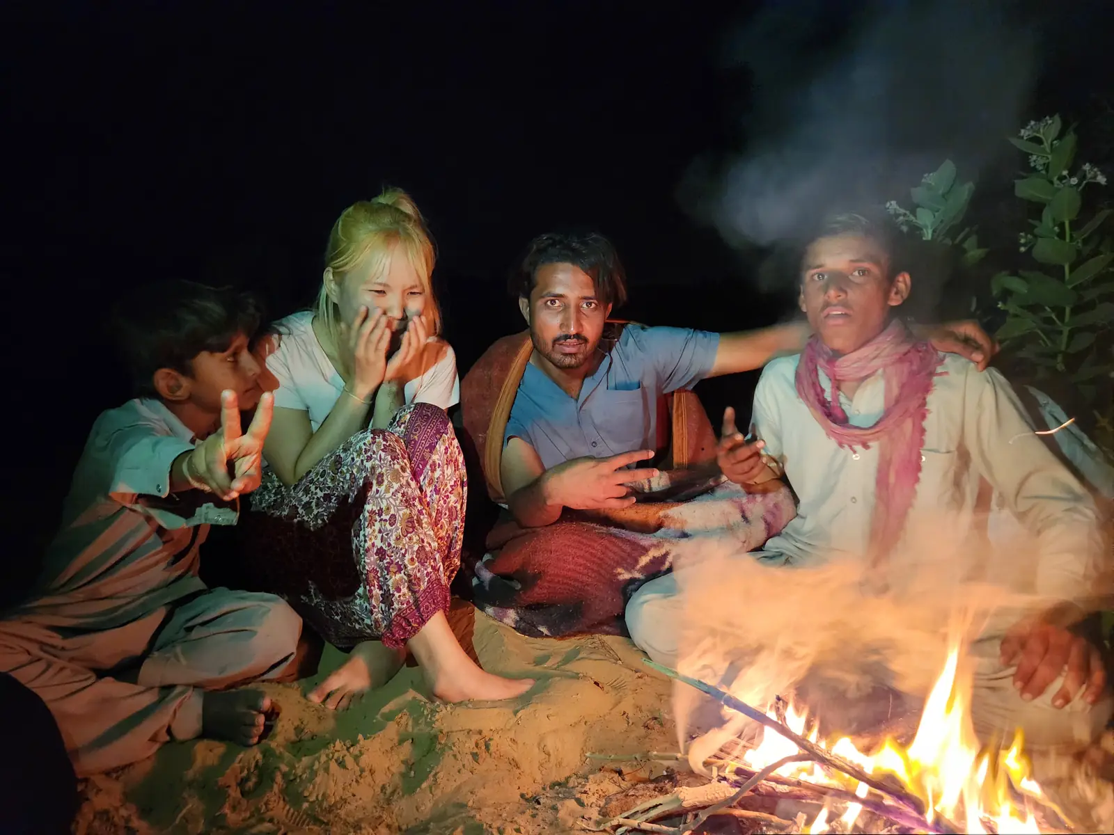Guests sitting close around the fire, talking