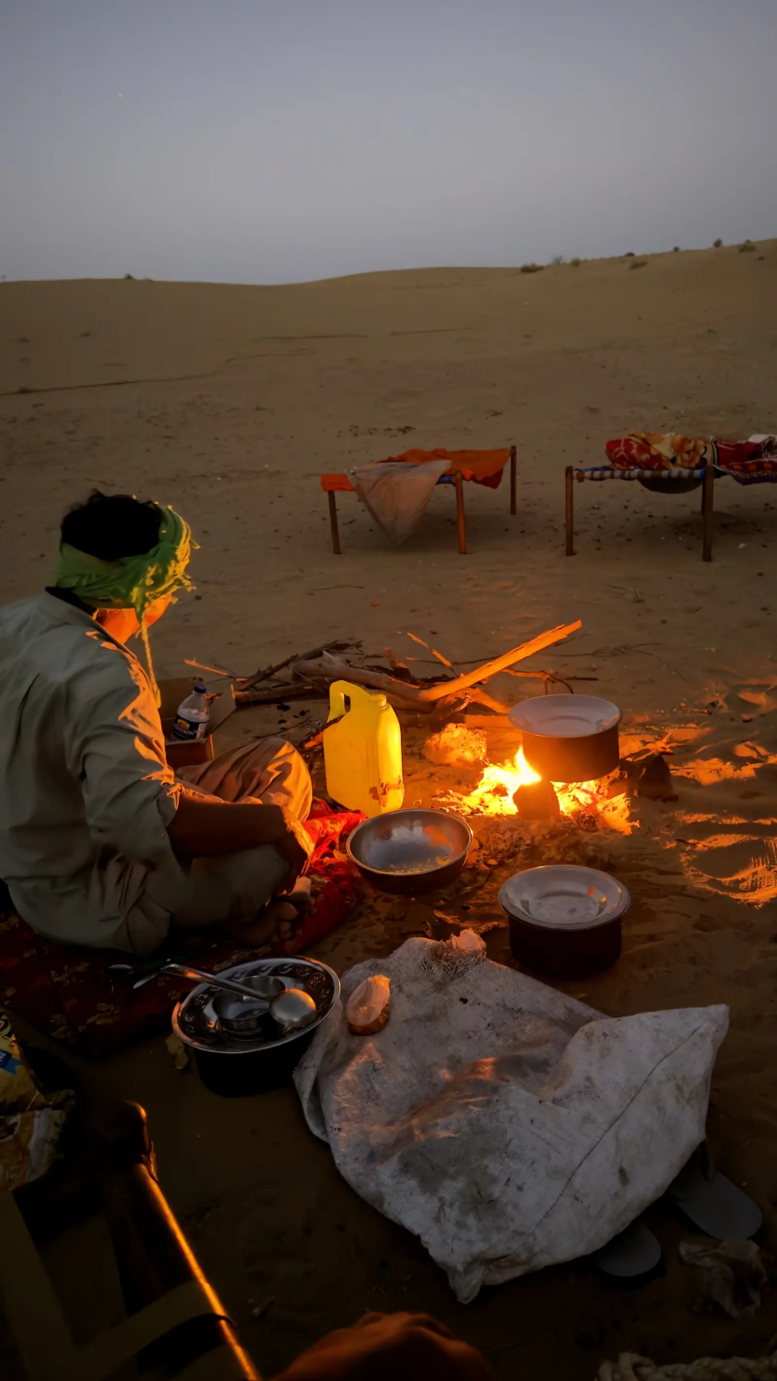 Dinner cooking over the fire, pots and plates laid out around it