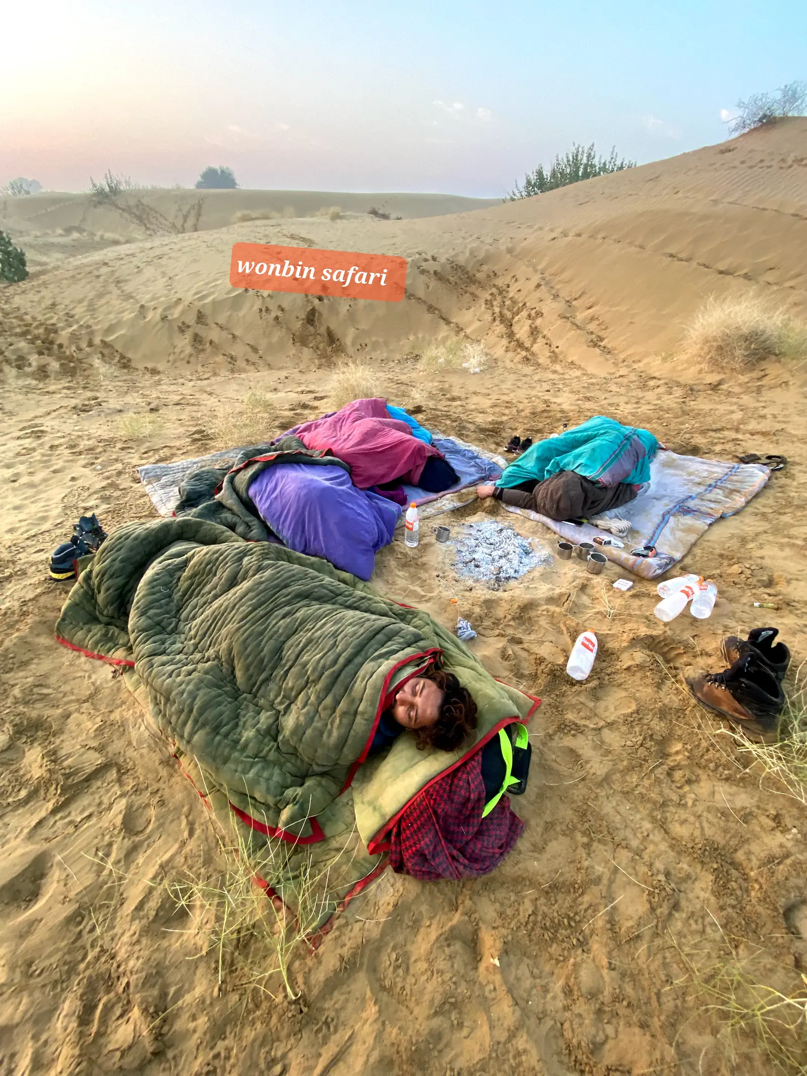 Guests asleep in bedrolls laid straight onto the sand