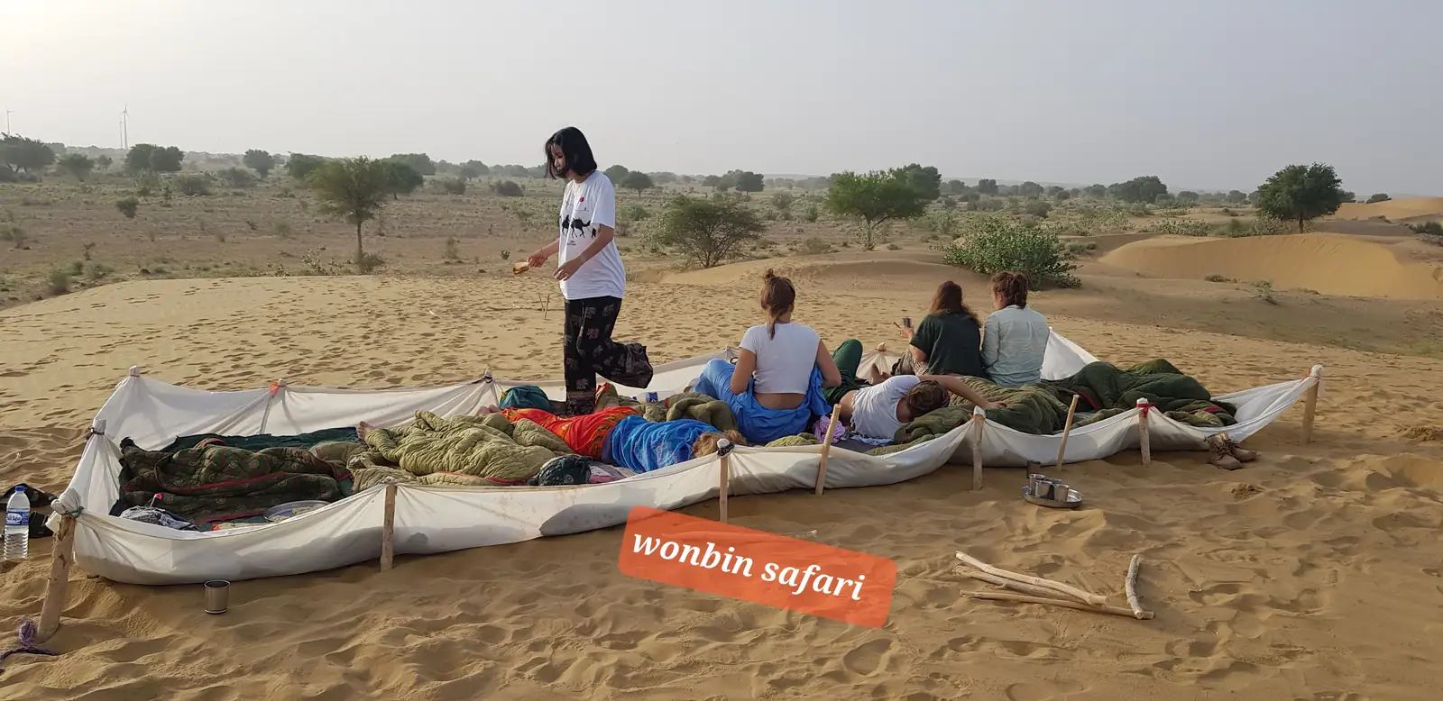 Beds set out in a row on the open sand for the night