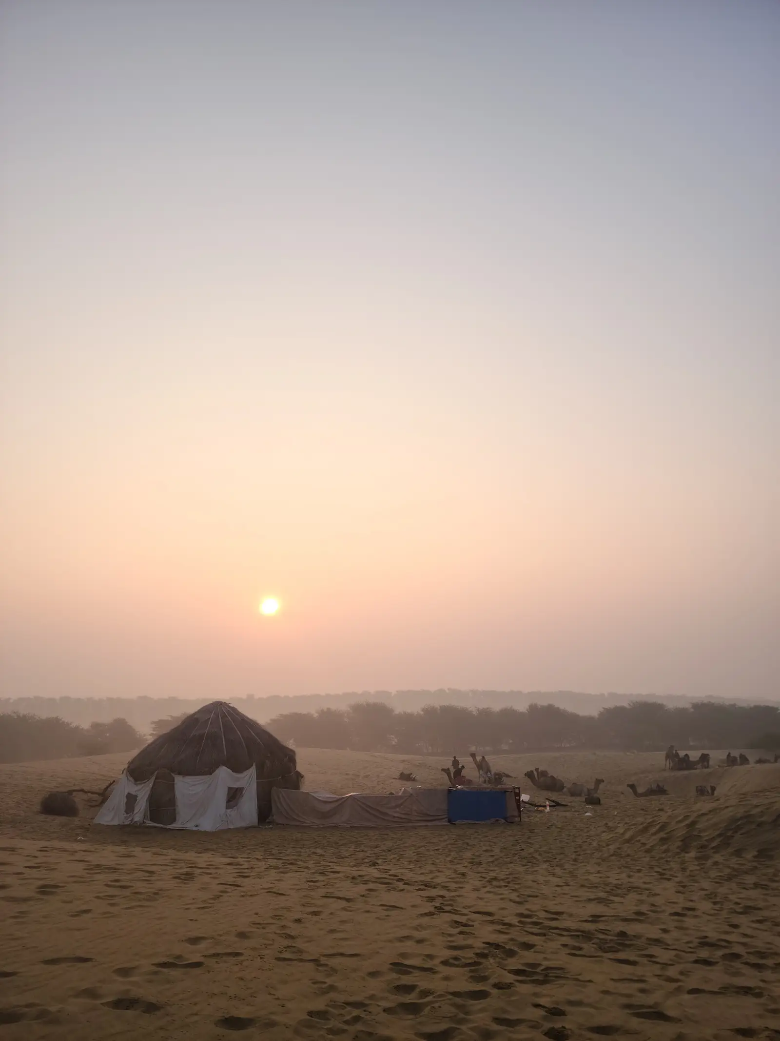 The sun coming up hazy over the camp huts