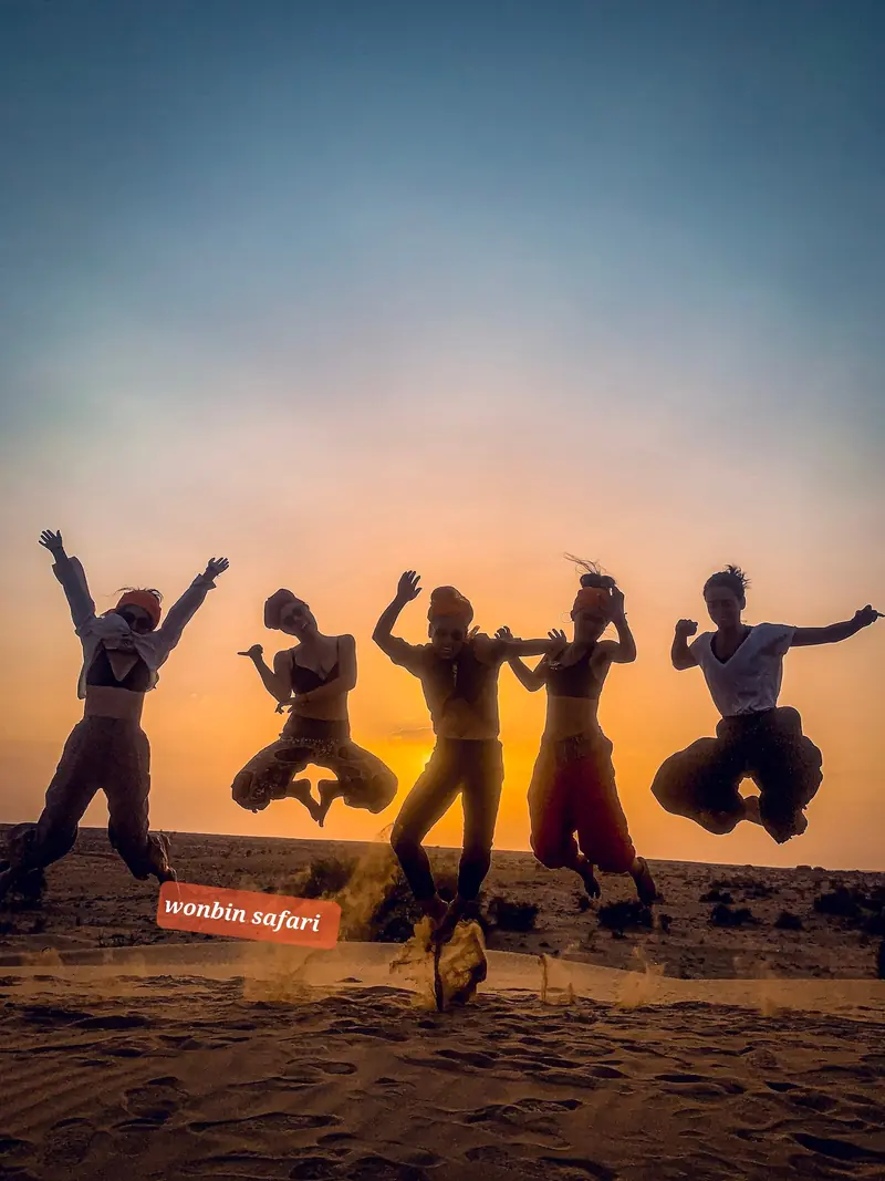 Five guests jumping in silhouette against the setting sun