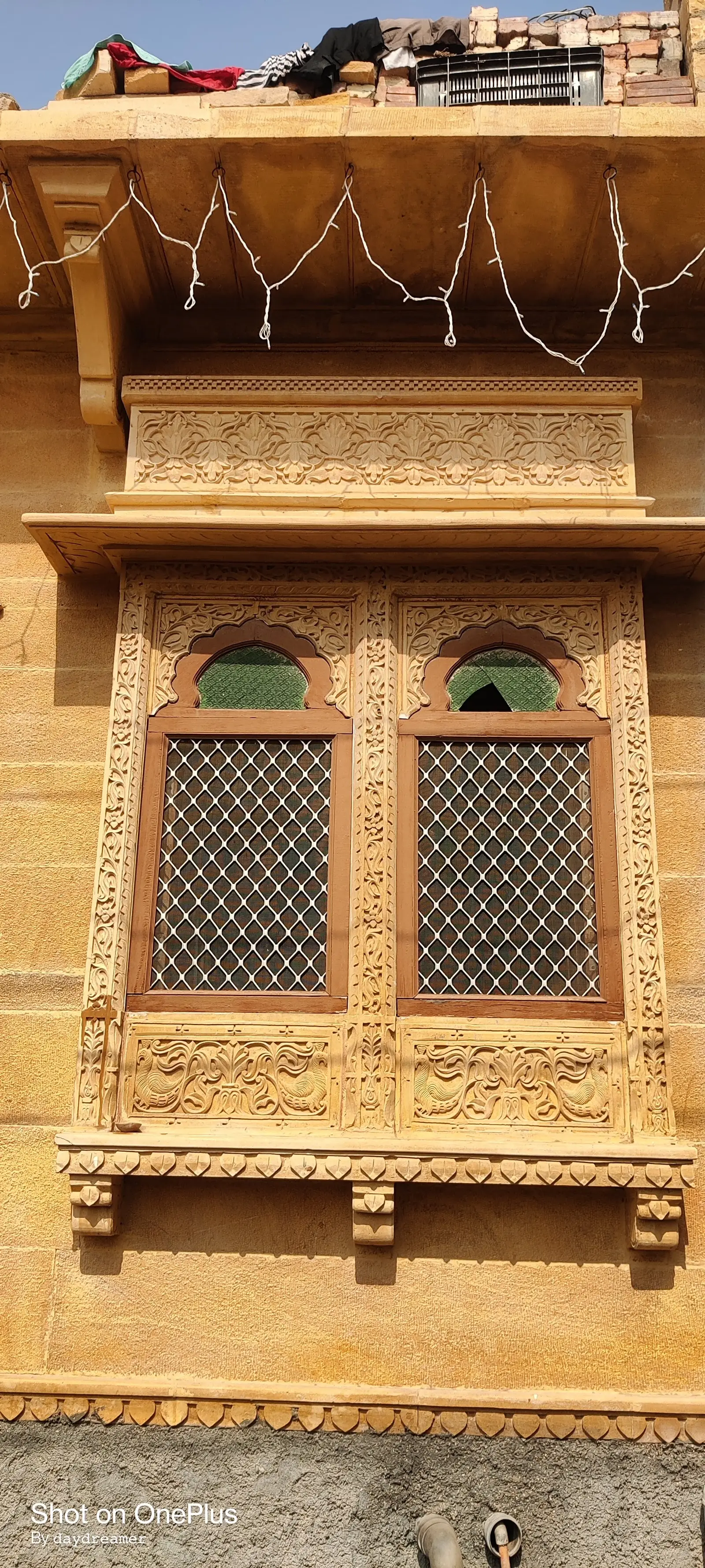 A carved jharokha window on the front of the building