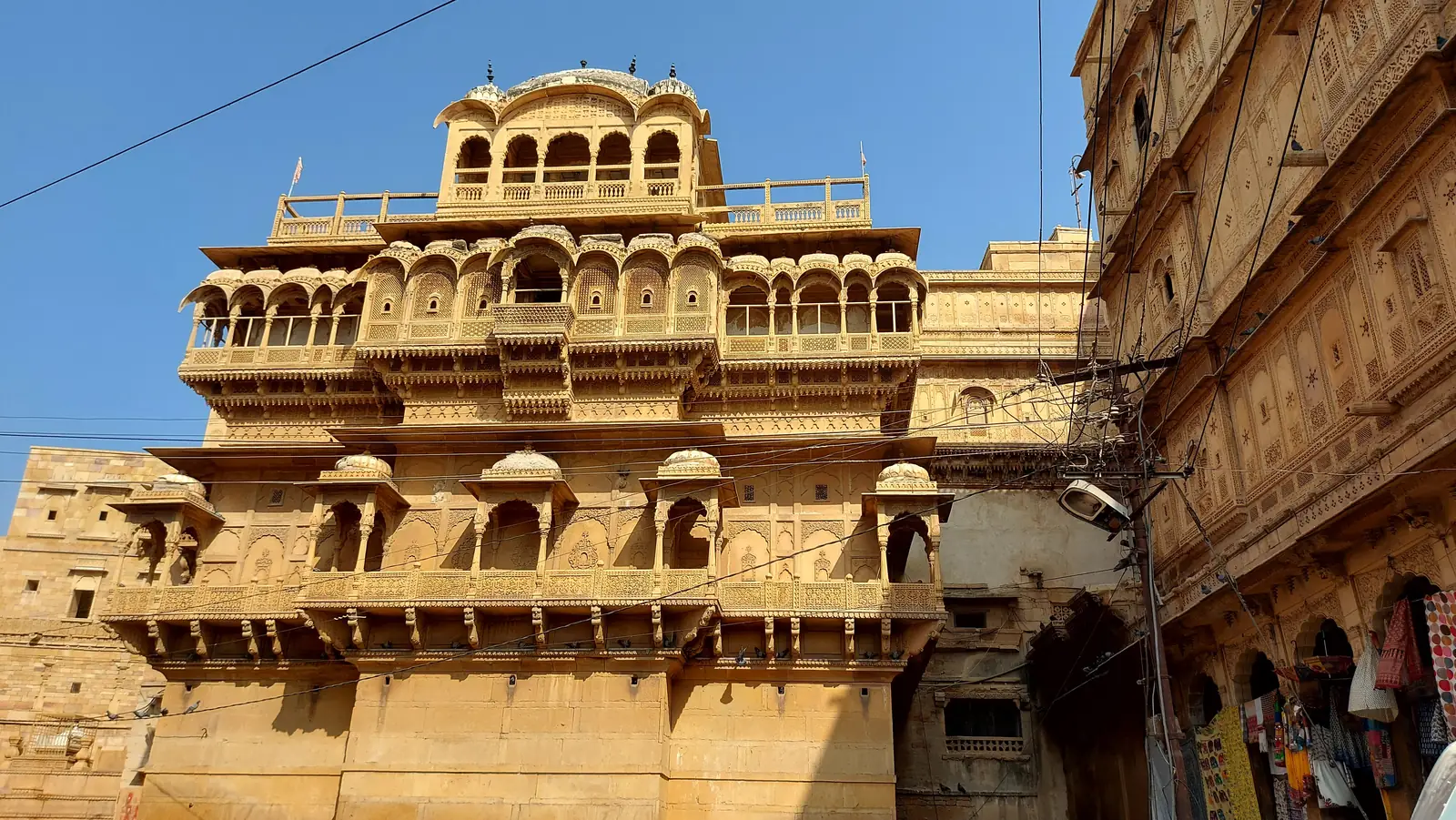 Sandstone balconies and a domed pavilion above the street