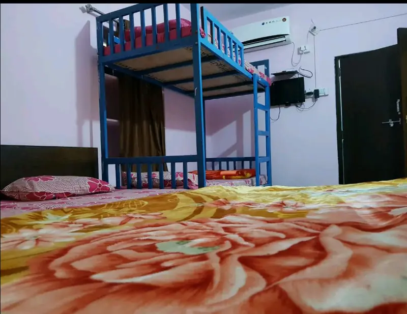 A dormitory bed, bunks against the wall