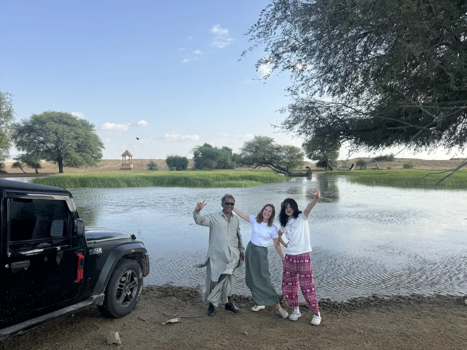 The jeep and a group beside an oasis pool on the road out to the dunes