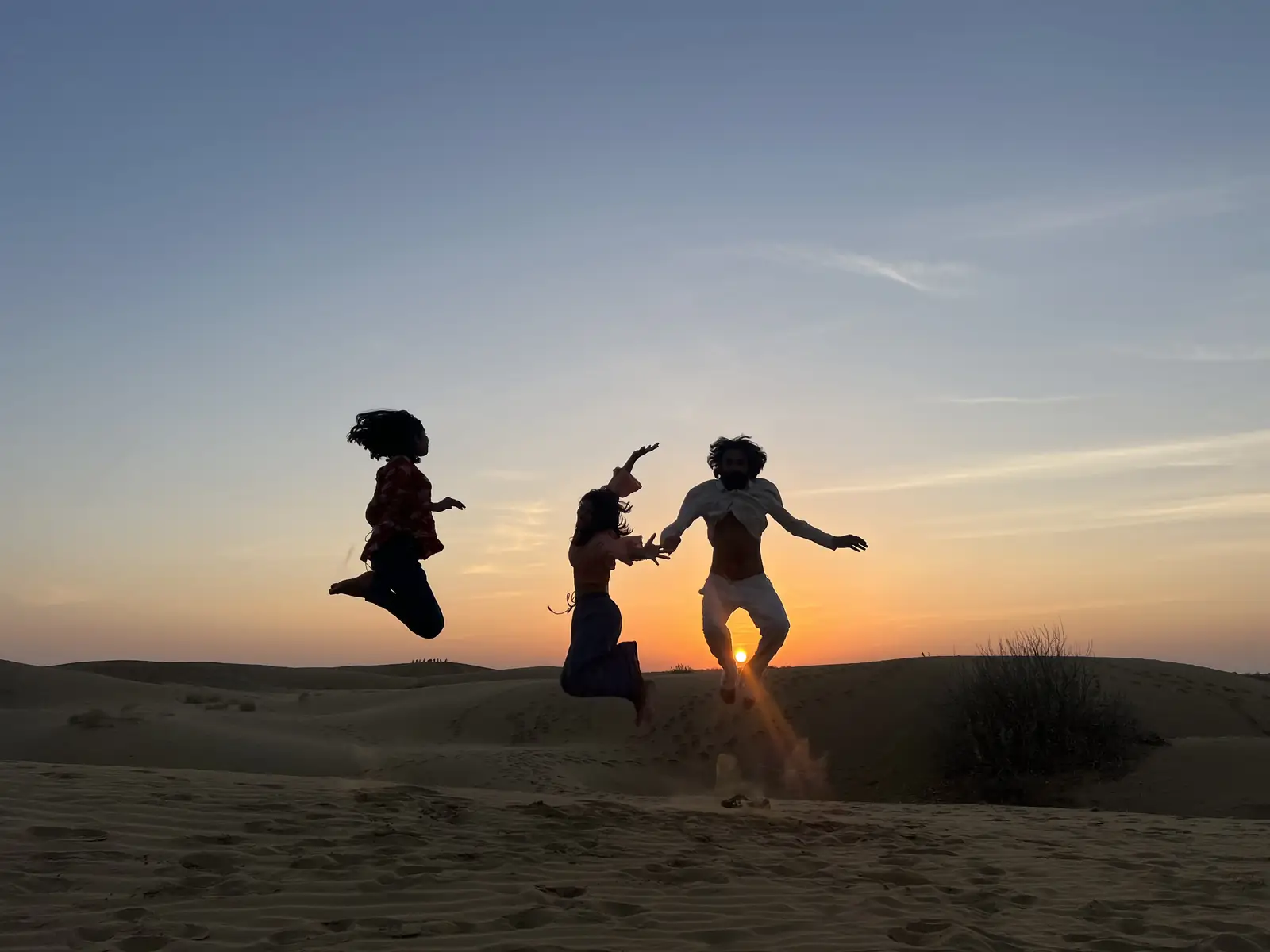 Three guests jumping in silhouette against the setting sun