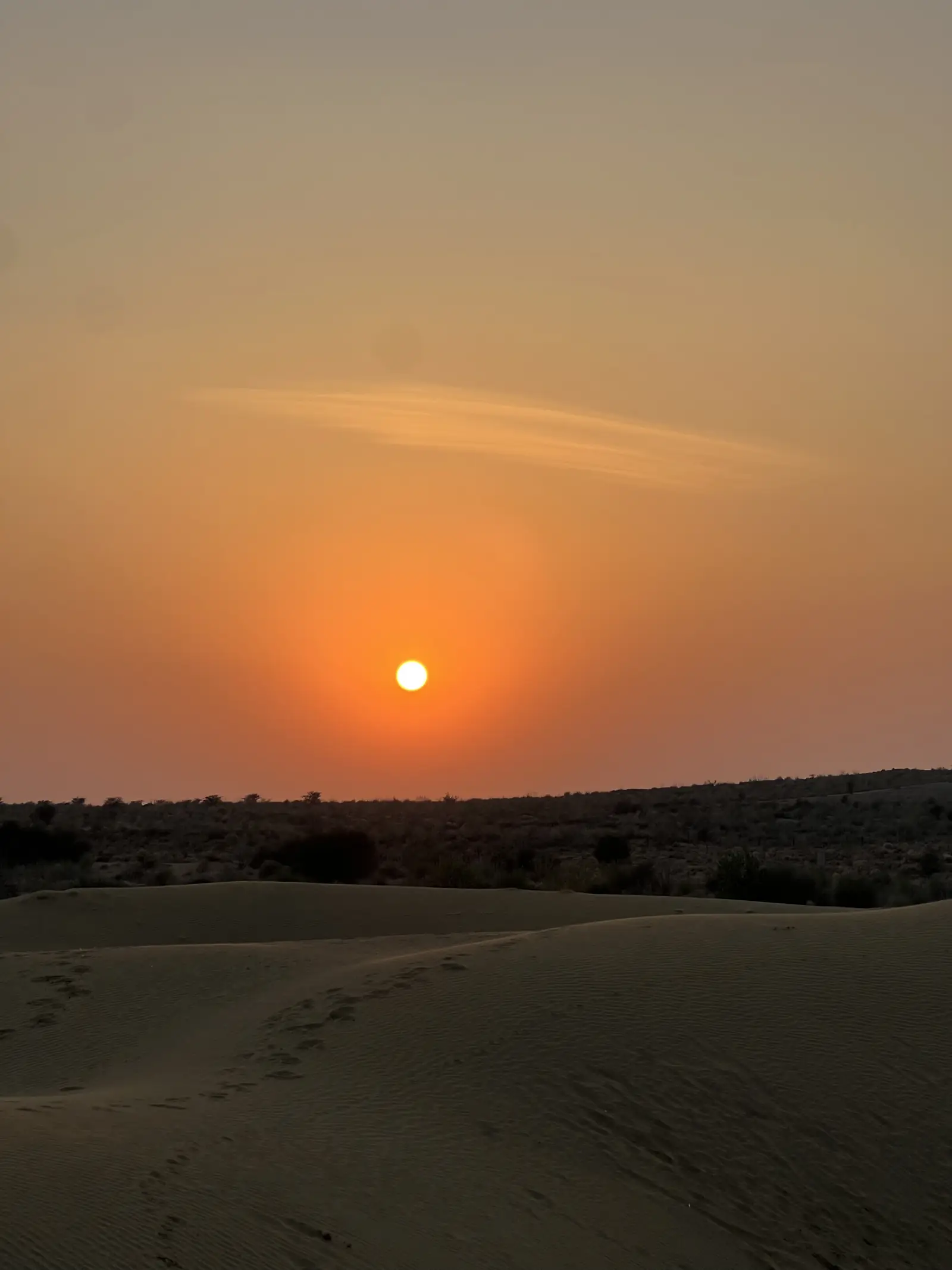A wide sunset over empty dunes, the sand still holding the heat of the day