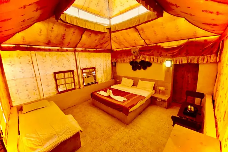 The warmly lit interior of a Swiss luxury tent at the Wonbin desert camp