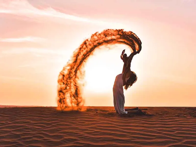 A fire dancer spinning a ring of flame at sunset during the cultural programme