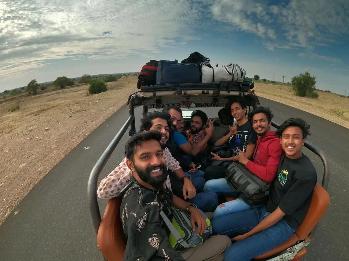 An open jeep loaded with luggage on the roof, setting out from Jaisalmer